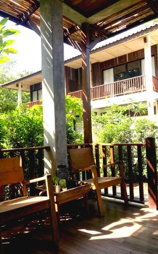 a porch with two wooden benches and a building at Sand in My Shoes Beach Loft in Thong Nai Pan Noi