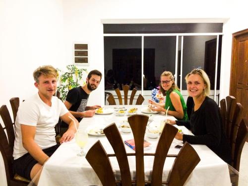 a group of people sitting around a table at Heaven Hills Guest House in Maskeliya