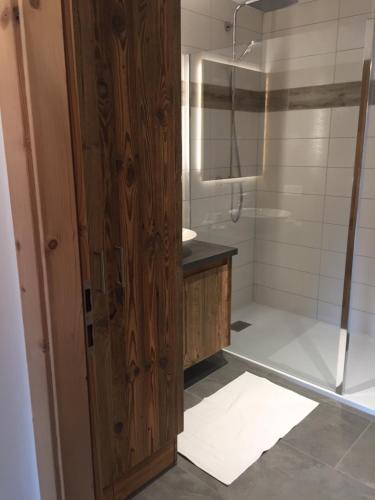 baño con ducha y puerta de madera en LA BRESSE - Appartement de Charme, en La Bresse