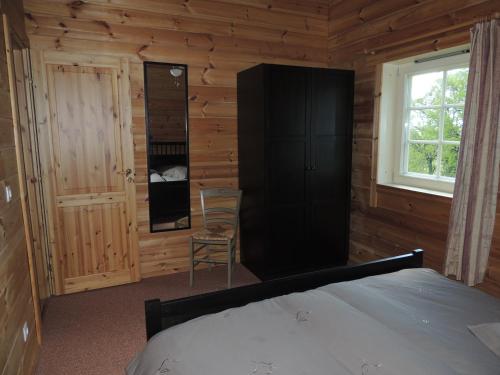 1 dormitorio con 1 cama en una cabaña de madera en Maisonnette L'Arrivée en Autoire