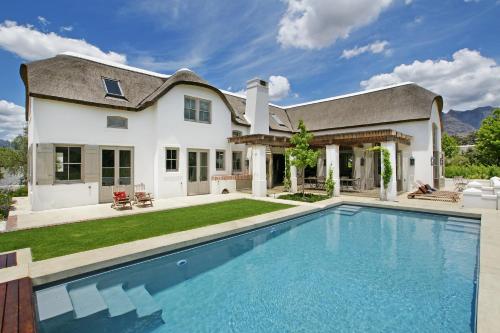 フランシュホークにあるVilla Simondiumの家の前にスイミングプールがある家