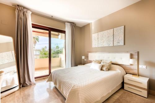 マルベーリャにあるApartamento Noray Playaのベッドルーム1室(ベッド1台、大きな窓付)