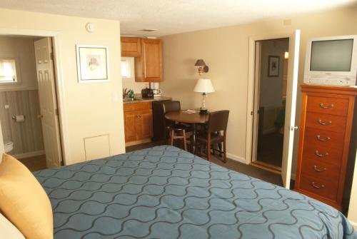 a bedroom with a bed and a kitchen with a table at Sands By The Sea Motel in York Beach