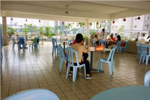 a group of people sitting at a table in a restaurant at Cozy Little Room at Suria Kipark Damansara Apartment with Single Bed and a Foldable Mattress in Kuala Lumpur