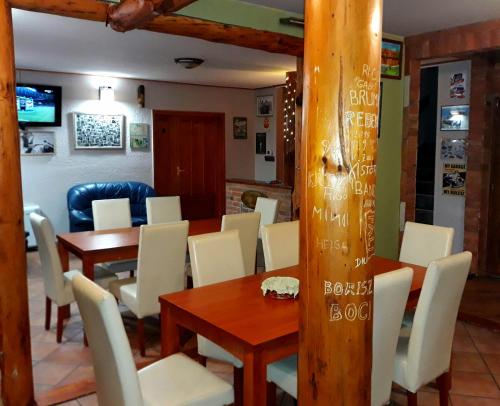 ein Esszimmer mit einem Tisch und weißen Stühlen in der Unterkunft OwlCastle-Bagolyvár in Hajdúszoboszló