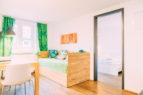 a bedroom with a bed and a desk and a mirror at Stadthaus Gut Hügle in Ravensburg