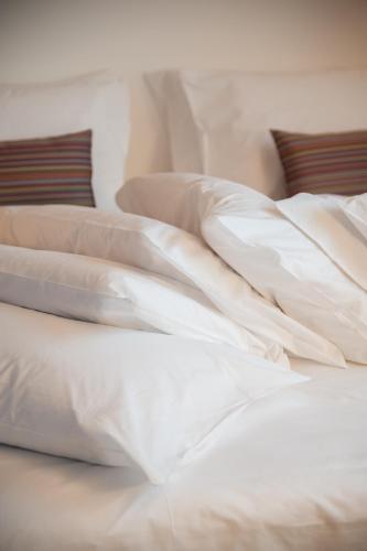 an unmade bed with white sheets and pillows at 8Piuhotel in Lecce