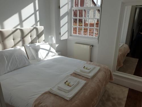 a bedroom with a bed with two towels on it at Lux Ribeira - ALL INCLUDED in Porto