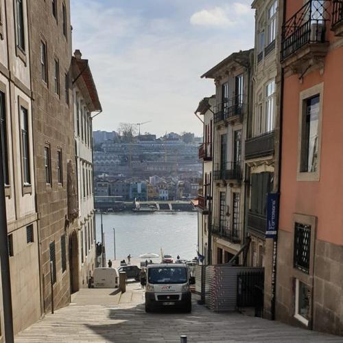 a car driving down a street between two buildings at Lux Ribeira - ALL INCLUDED in Porto