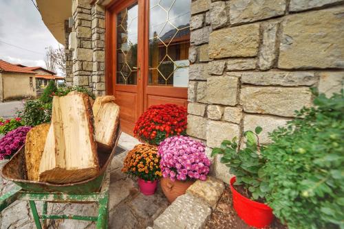 a bunch of flowers in pots in front of a building at To Balkoni tis Agorianis in Eptalofos