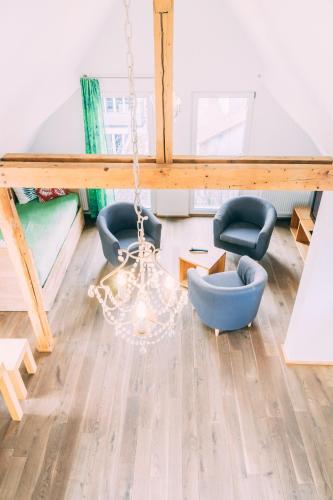 a living room with two chairs and a chandelier at Stadthaus Gut Hügle in Ravensburg
