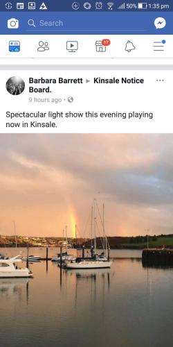 a website with a boat in the water with a rainbow at Daltons Bar in Kinsale
