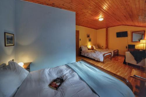 a large room with two beds and a room with a bed sqor at To Balkoni tis Agorianis in Eptalofos