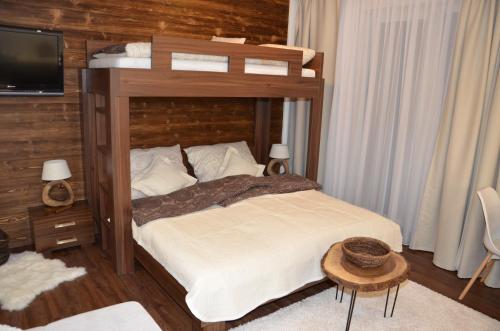 a bedroom with a large bed with a wooden headboard at Primo Maxi in Smokovce