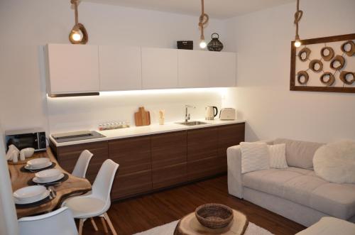 a kitchen and living room with a couch and a table at Primo Maxi in Smokovce
