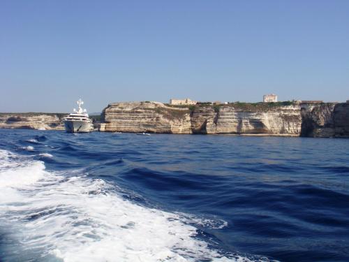a boat in the water next to some cliffs at Santateresa in Bonifacio