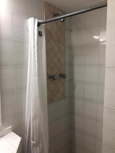 a shower with a shower curtain in a bathroom at San Marco Hotel Curacao & Casino in Willemstad