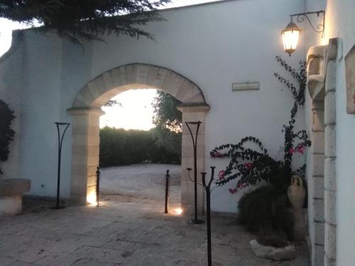 una entrada a un edificio blanco con un arco en Masseria Lapica, en Oria