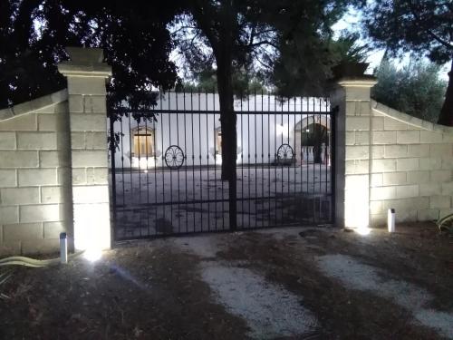 une clôture avec une porte éclairée dans l'établissement Masseria Lapica, à Oria