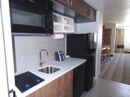 a kitchen with a sink and a black refrigerator at MainStay Suites Coeur d'Alene in Coeur d'Alene