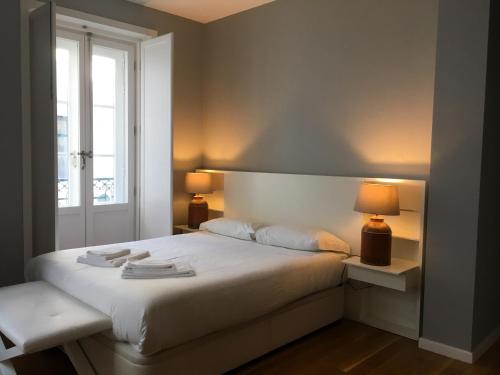 a bedroom with a white bed with a window at Baixa Chiado Áurea Apartment in Lisbon