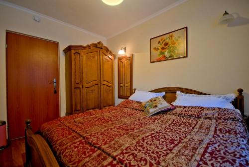 ザコパネにあるPokoje u Jankaのベッドルーム1室(大型ベッド1台、木製キャビネット付)