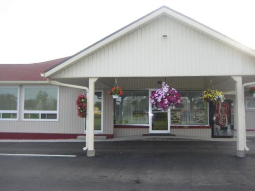 a store with flower baskets on the front of it at Majers Motel in Stratford