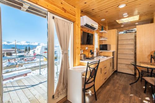 a kitchen with a table and chairs and a large window at Tiny House Leadville Colorado in Leadville