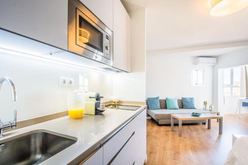 a kitchen with a sink and a living room at Esmeralda, Pet Friendly, Sea View, Wifi, Near the Beach in La Cala de Mijas