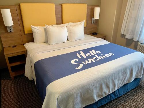 a hotel room with a bed with a hello swimming sign on it at Days Inn by Wyndham Brooklyn Borough Park in Brooklyn