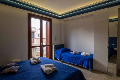 sypialnia z 2 łóżkami i ręcznikami w obiekcie Elisir Suite Rooms by Marino Tourist w mieście San Vito lo Capo