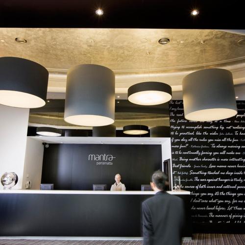 a man in a suit standing in front of a counter at Mantra Parramatta in Sydney