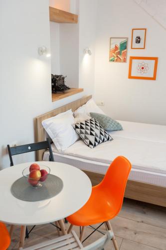 a small room with a bed and a table and chairs at 7 Apartments in Lviv