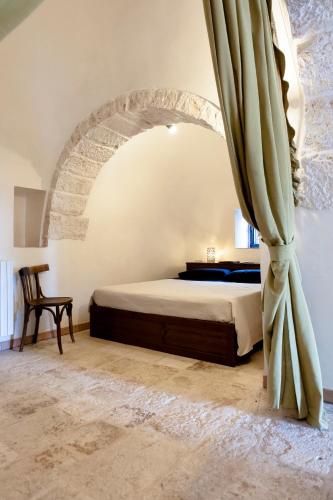 a bedroom with a bed and a large curtain at Trullo Dimora della Valle in Locorotondo