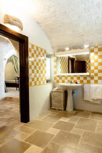 a bathroom with a sink and a mirror at Trullo Dimora della Valle in Locorotondo