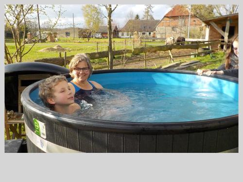 een vrouw en een kind in een hot tub bij Ferienhaus Raabe in Splietsdorf