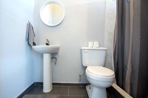 a bathroom with a toilet and a sink and a mirror at Casa Santurce in San Juan