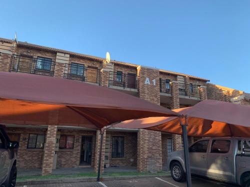 a van parked in a parking lot in front of a building at The Wilcrest Apartment in Randjesfontein