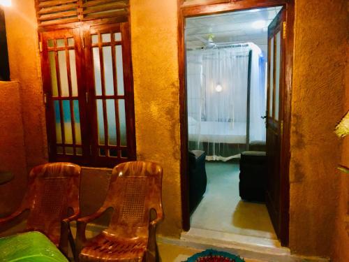 two chairs sitting in front of a door with a mirror at Sea Breeze Garden in Tangalle