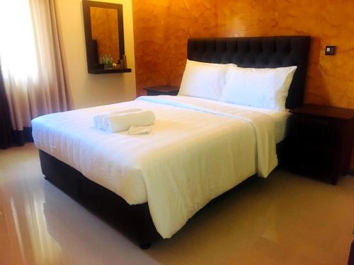 a bedroom with a large bed with a white blanket at Forever City Hotel in Kiribathgoda