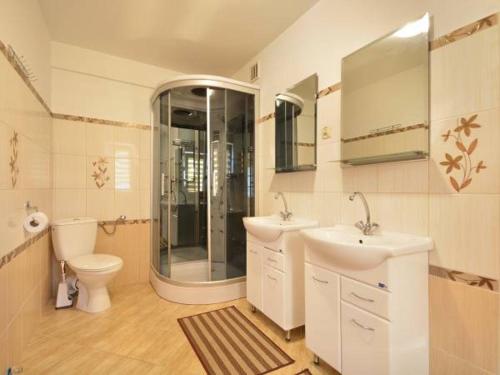 a bathroom with two sinks and a shower and a toilet at Noclegi u Agatki in Ustrzyki Dolne