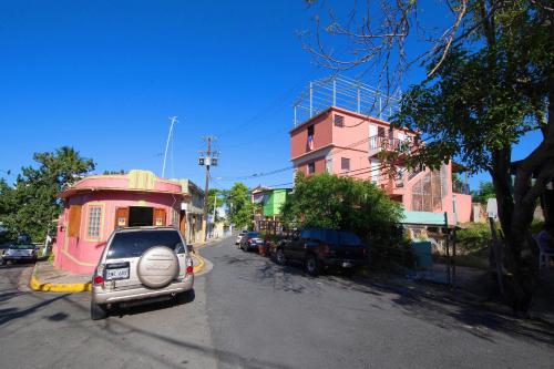 a car parked next to a pink building on a street at Casa Santurce in San Juan
