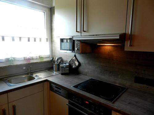 a kitchen with a stove and a sink and a window at Miramar in Bremerhaven