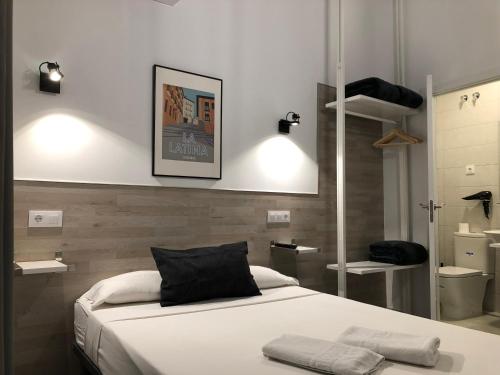 a bedroom with a bed with two towels on it at Hostal Rías Bajas in Madrid