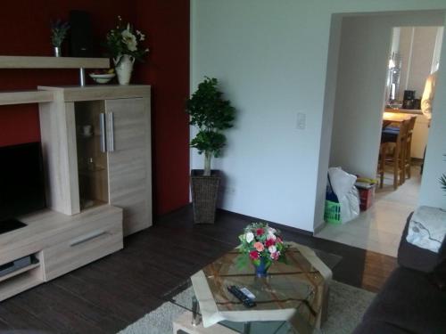 a living room with a tv and a glass table at Miramar in Bremerhaven