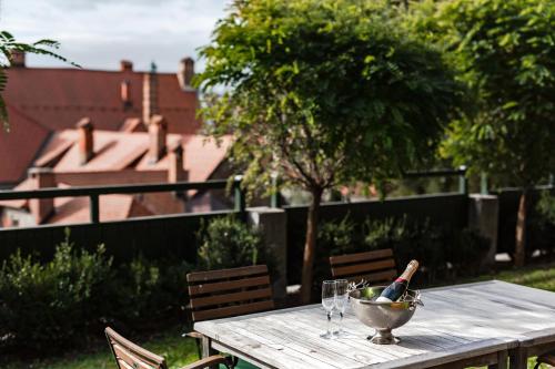 a table with a bowl of grapes and a bottle of wine at Lesar Hotel Angel - Member of Hip Hotels in Ljubljana