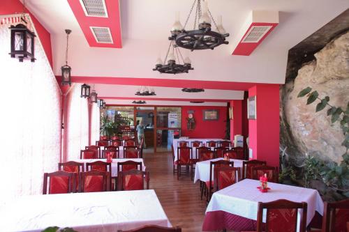 a restaurant with red walls and tables and chairs at Ribarska Sreshta Family Hotel in Tsarevo