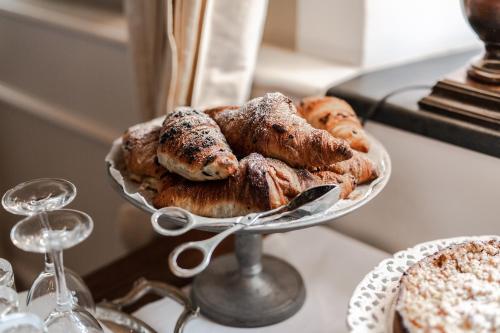 a plate of pastries on a table with a wine glass at Lesar Hotel Angel - Member of Hip Hotels in Ljubljana