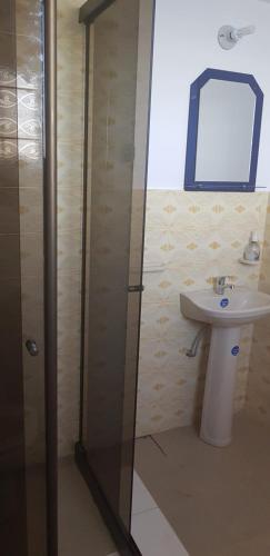 a bathroom with a shower and a sink and a mirror at Hostal Phaxsi in Comunidad Yumani