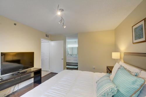 a bedroom with a bed and a flat screen tv at Renovated 2/2 Unit at Yacht Club/Aventura in Aventura